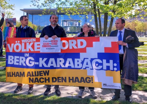 Demonstration outside chancellor’s office, with a sign on a Karabakh flag saying “For genocide in Nagorno Karabakh, send Aliyev to the Hague.” (Gabi Damm photo)
