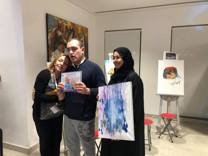 Sona Petrosyan and son Raphael Martirosyan from My Way, at Art for All Center with Ms. Mona Abdul Karim, SCHS Director, holding painting by My Way student Eva Ghazanchyan
